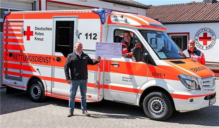 Zur Beschaffung eines neuen Notfall-Beatmungsgeräts für den RTW des DRK-Ortsvereins Sinzig e.V. übergibt Norman Wirbel (li.) eine Spende an DRK-Bereitschaftsleiter Marco Hengsberg (Mitte, im Fahrzeug) und den zweiten DRK-Ortsvereinsvorsitzenden Martin Hengsberg (re.). Foto: Thorsten Trütgen