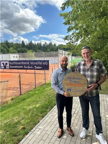 Zur Übergabe der Spende, trafen sich Regionalmarktleiter Mark Palmersheim und der zweite Vorsitzende des TC Meckenheim Erwin Winkler, auf der Sportanlage des Vereins. Foto: Raiffeisenbank Voreifel eG