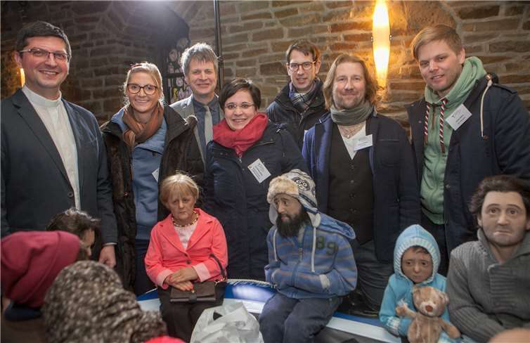 Zusammen mit Kanzlerin Angela Merkel und einigen Flüchtlingen im „Schlauchboot“ präsentierten sich die Organisatoren der Ausstellung „„Flucht beWEGt“ in der Pfarrkirche Buschhoven. JOST