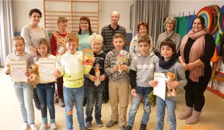 Zusammen mit der Jury, den Klassenlehrerinnen, den Organisatorinnen und den weiteren Mitstreitern freuen sich die Sieger des Vorlesewettbewerbes über ihre neuen „Haustiere“: (v.l.) Constanze Vogel, Neele Kirchhof und Theodor de Abreu. Privat