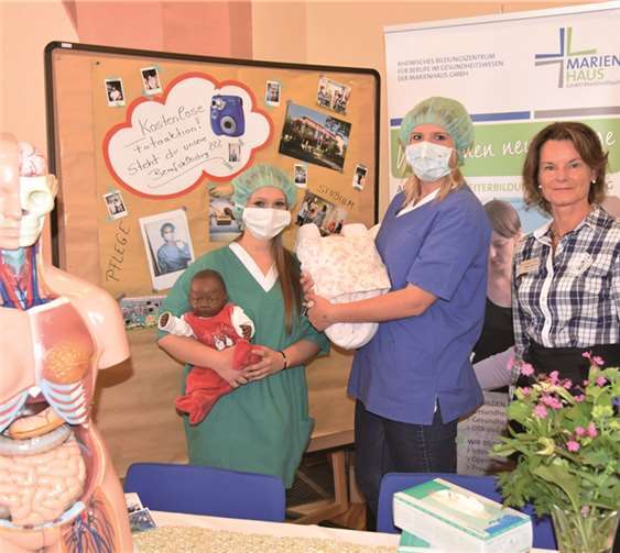 Zwei Auszubildende und Sylke Jadischke (r.) präsentieren das Leistungsspektrum des Rheinischen Bildungszentrums für Berufe im Gesundheitswesen der Marienhaus Kliniken GmbH.