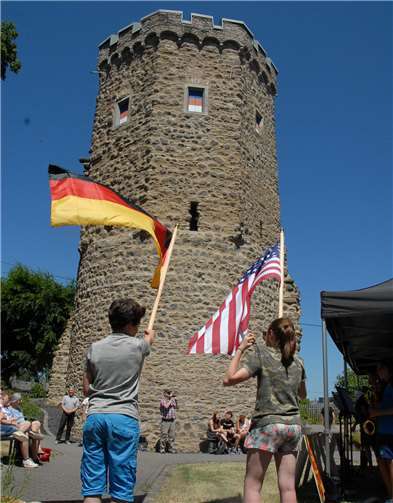 Zwei Schüler schwenkten vor dem Turmdie deutsche und die amerikanische Flagge..