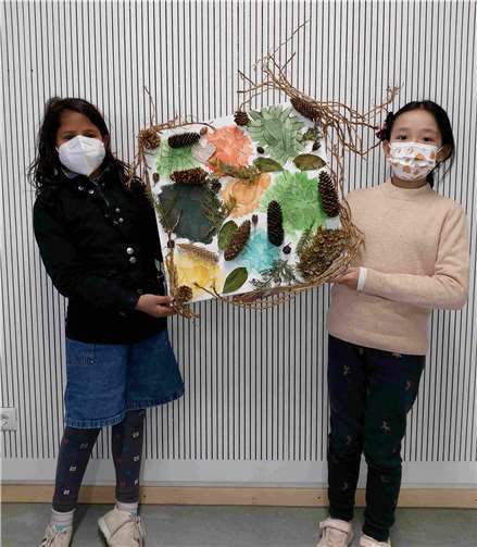 Zwei Schülerinnen der Gemeinschaftsgrundschule Meckenheim-Merl, die stolz ihr Bild präsentieren, das sie während der Osterferien in der Schule erstellt haben. Foto: privat