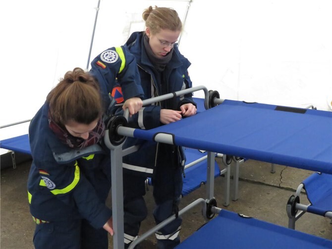 Zwei THW-Einsatzkräfte bauen ein Doppelstockbett auf.  Foto: THW Ahrweiler, Arnulf)