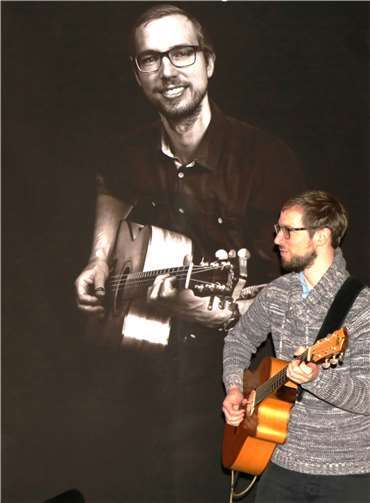 Zweimal Simon Wahl: einmal live an der Gitarre, im Hintergrund auf einem der ausgestellten Portraitfotos. Foto: SCHÜ