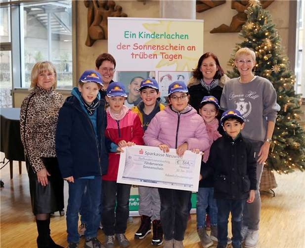 Zweite Reihe von links: Sonnenschein-Vorstand Ulrike Börder-Sauerbrei, Stationsleitung Elisabeth Paffhausen, Annette Krings sowie Kinder der Adventsfenstersänger und Stationsleitung Kerstin Bornhofen bei der Spendenübergabe  Foto: Harald Sauerbrei