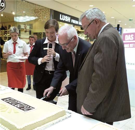 v. li.) Kerstin Jackenkroll, Helmut Gehres und Oberbürgermeister Hofmann-Göttig schneiden gemeinsam die Geburtstagstorte an. Fotos: BSB