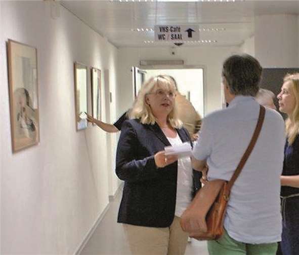 v.l.: Jutta Golinski (Leiterin der vhs) im Gespräch mit einem Besucher der Vernissage, rechts die Künstlerin Nicole Heidel.privat