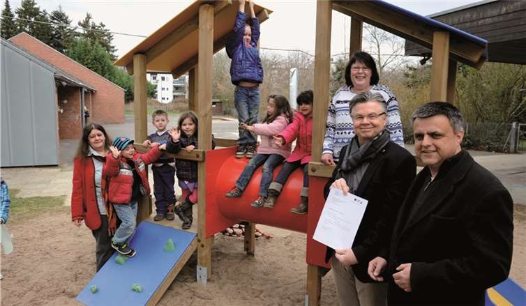 v.l. Kita-Leiterin Helga Pollig (rote Jacke), Kinder der Tagesstätte, Günther Langen (Präsident Lions), Pastor Dörrenbächer und Bianca Funke, Vorsitzende des Fördervereins Tagesstätte (auf Spielgerät).Fix