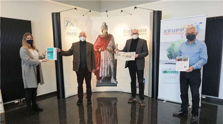 (v.l.): Linda Krupp (KRUPP DRUCK, Sinzig) übergibt das Zertifikat an Pfarrer Jürgen Gundalin. Gemeindeamtsleiter Andreas J. Schulte präsentiert die erste Doppelseite 2021, Peter Krupp (Geschäftsführer KRUPP DRUCK, Sinzig) präsentiert das unterstützte Projekt in Kenia. Foto: ROB