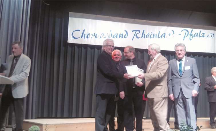 (v.l.n.r.) Chormanager Werner Mattern; Schatzmeister des Chorverbandes und des SonntagsChores Rheinland-Pfalz, Hans-Jürgen Konrad; Der künstlerische Leiter vom SonntagsChor, Mario Siry; Karl Wolff, Präsident und Peter Balmes, Vizepräsident des Chorverbandes Rheinland-Pfalz. Ganz links im Bild (sich zum Pult begebend) Jury-Mitglied und Verbands-Chorleiter Michael Rinscheid. Privat
