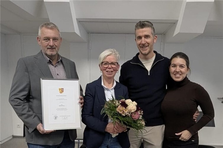 (v.l.n.r.): Der Erste Beigeordnete Christoph Kicherer händigt Waltraud Stenz im Beisein ihres Sohnes Sven und dessen Frau Leila die Dankurkunde der Verbandsgemeinde Vordereifel für die geleisteten Dienste aus.