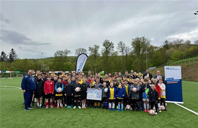 vlnr.: Die Teilnehmenden des Fußballcamps, Piet Ahrens (Tribünenmoderator des MSV Duisburg, Jugendförderung und Talentsichtung), Thomas Brust (Privatkundenberater der VR Bank RheinAhrEifel in Niederzissen), Sebastian Bell (Abwehrspieler des 1. FSV Mainz) und Michael Lenz (Filialleiter und Privatkundenbetreuer der VR Bank RheinAhrEifel in Niederzissen) bei der Scheckübergabe