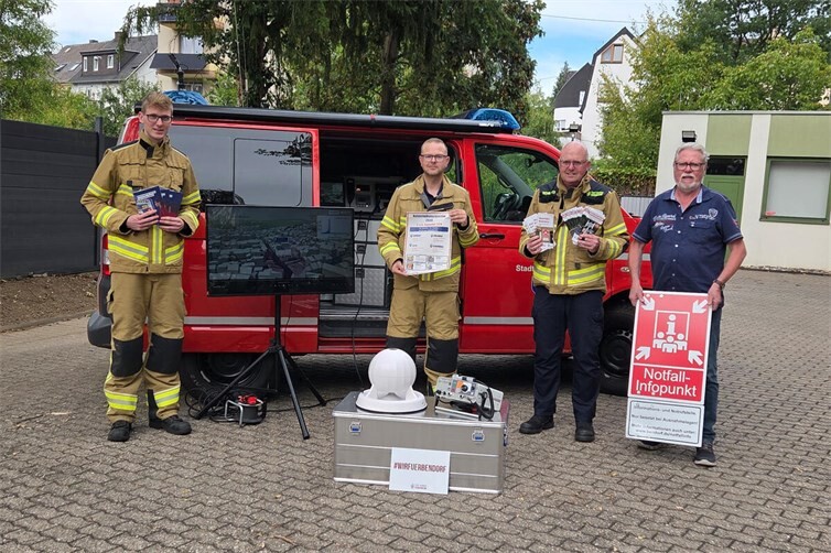 (v.l.n.r.): Lars Janßen und Tobias Hilgert vom Social Media Team der Feuerwehr Bendorf machen mit Wehrleiter Markus Janßen und dem Ersten Beigeordneten Peter Schneider mit Informationsmaterial, Hochwasservisualisierung, mobiler Sirene und dem Hinweis auf die Notfallinfopunkte auf den Katastrophenschutztag am 5. und 6. September aufmerksam.